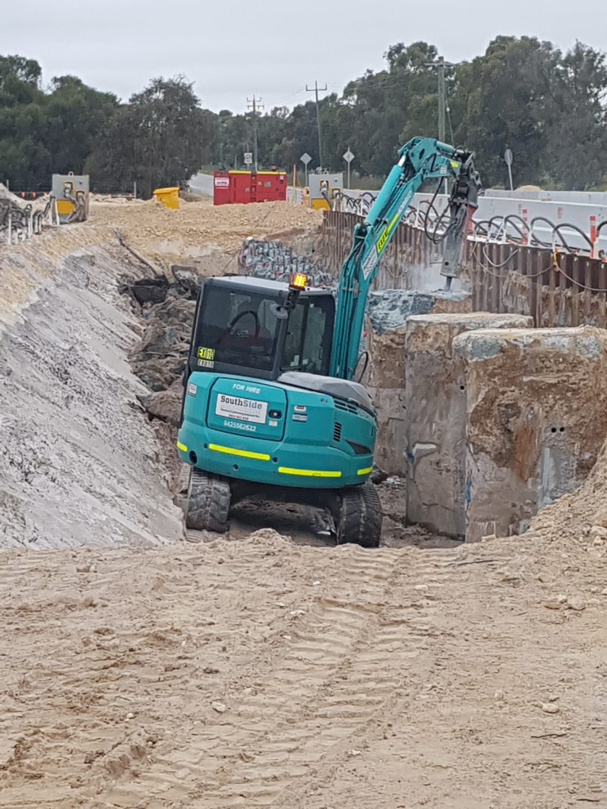 A blue excavator is working on a construction site.
