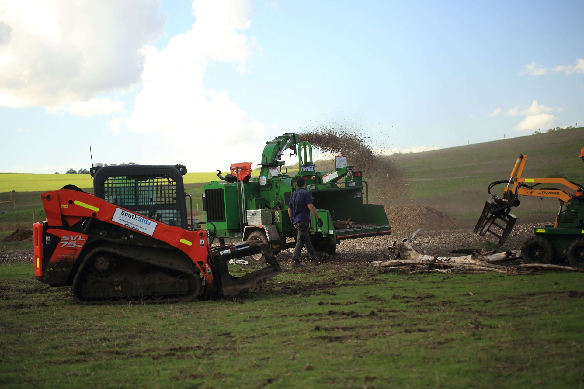 A man is standing next to a tractor in a field.