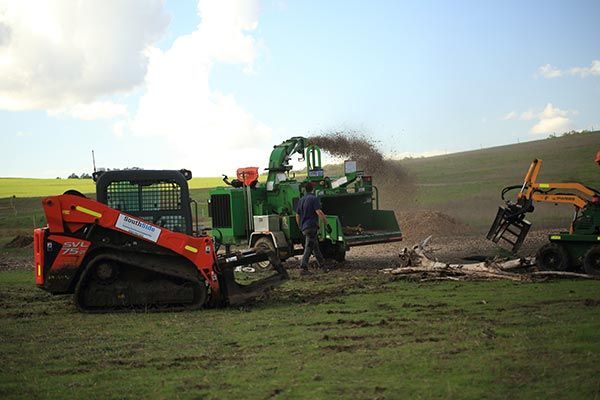 A man is standing next to a tractor in a field.