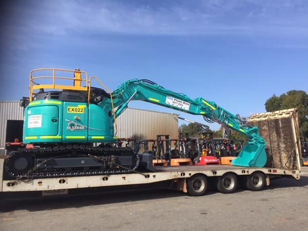 A large excavator is sitting on top of a trailer.