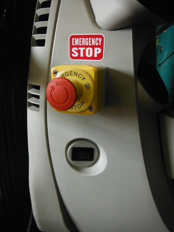 A red and yellow emergency stop button on a white surface