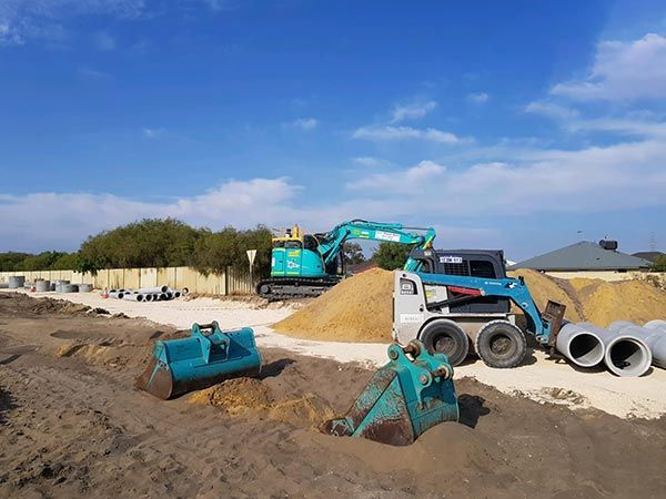 A construction site with a lot of machinery and pipes.