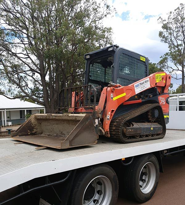 A bulldozer is sitting on top of a flatbed truck.