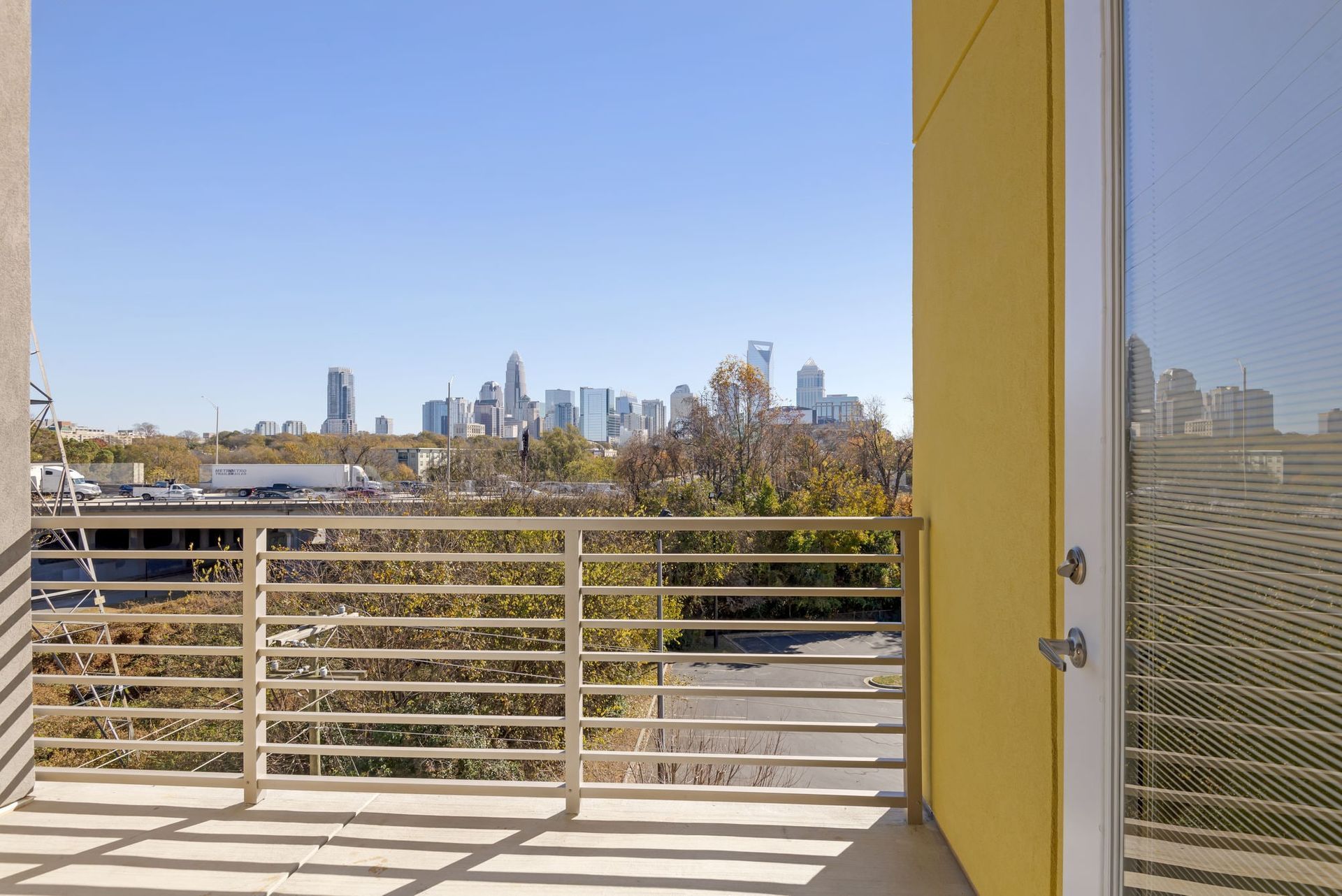 Balcony railing with a city skyline view from a residential building.