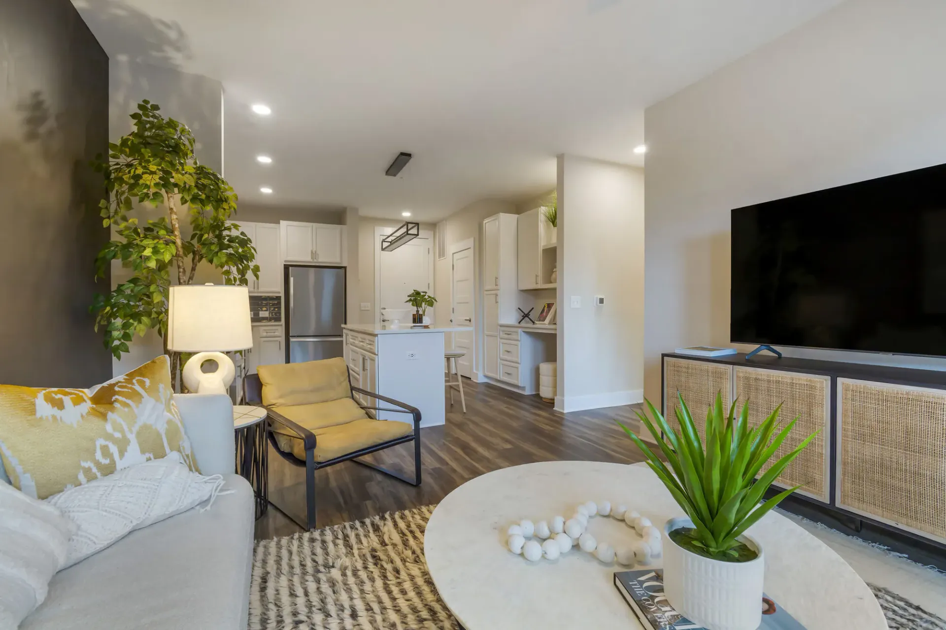 Open-concept living area with kitchen island, seating, and a large TV.