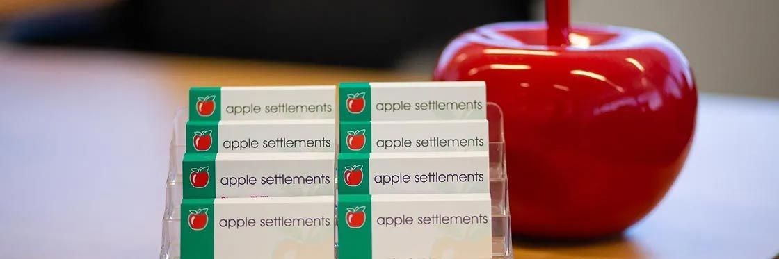 Rows of medicine packs beside a red apple on a wooden surface