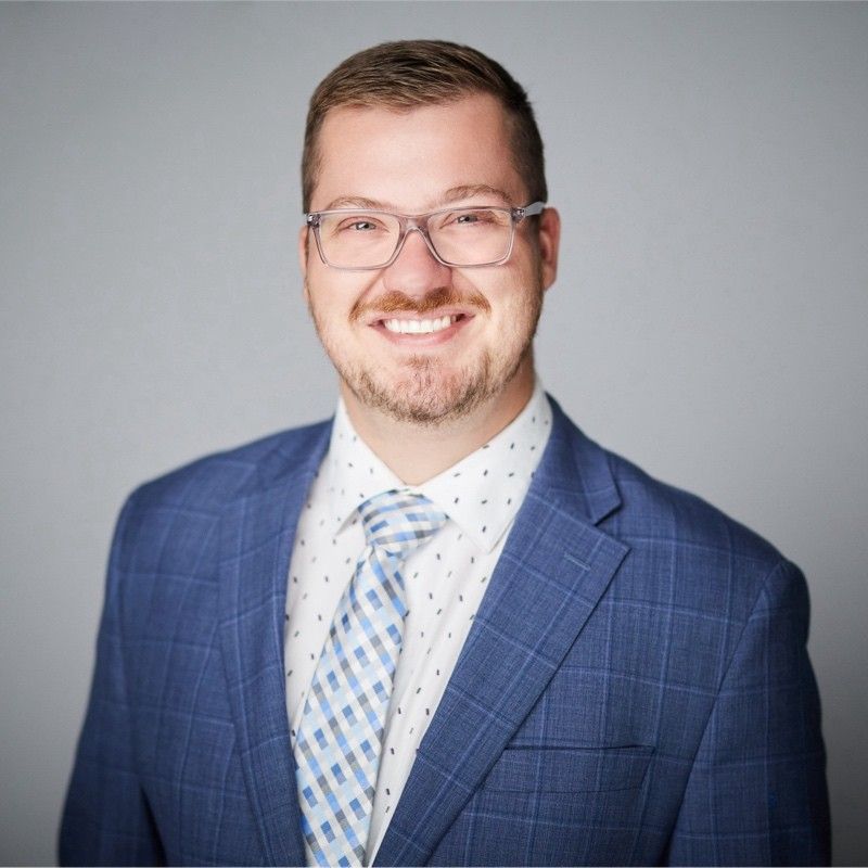 A woman in a green tank top is smiling for the camera.
