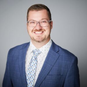 A man in a suit and tie is smiling for the camera.