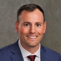 A man in a suit and tie is smiling for the camera.