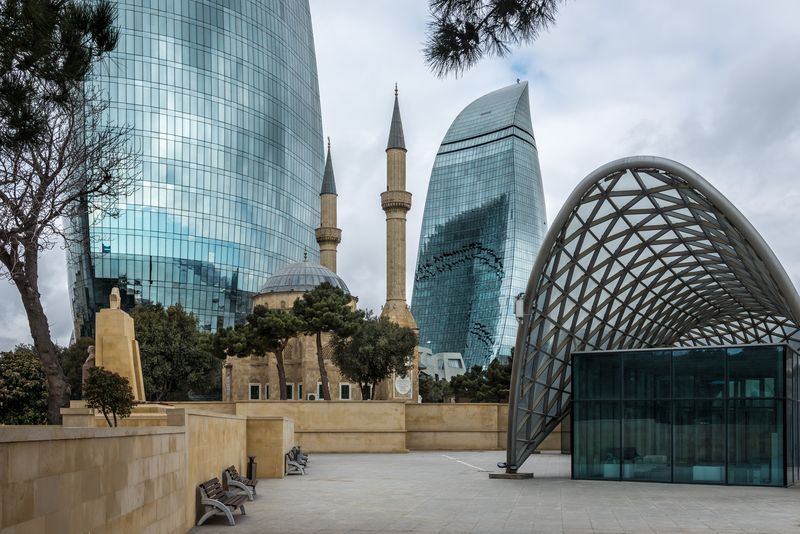 A mosque is surrounded by tall buildings in a city.