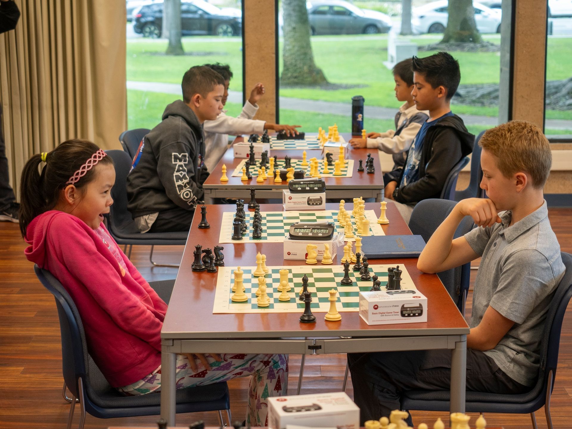 A group of children are playing chess in a room.