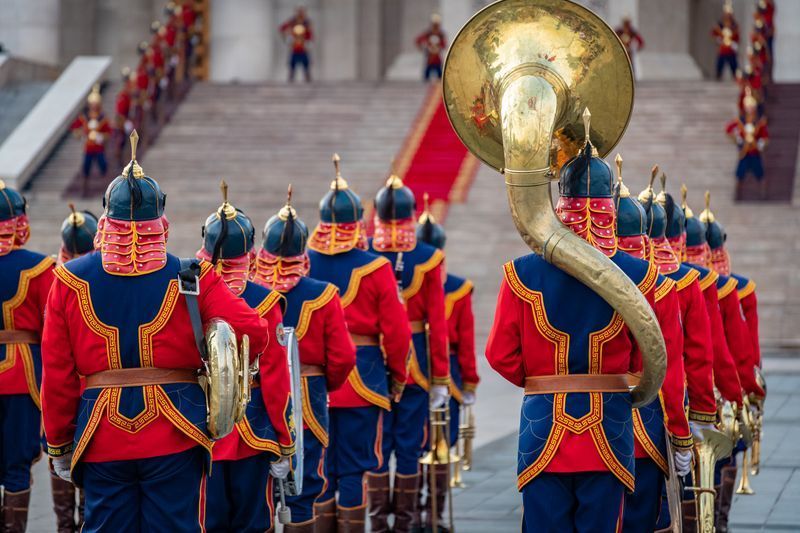 A group of men in military uniforms marching in a parade.