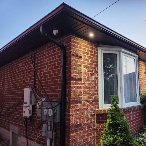 A brick house with a window and a drain pipe