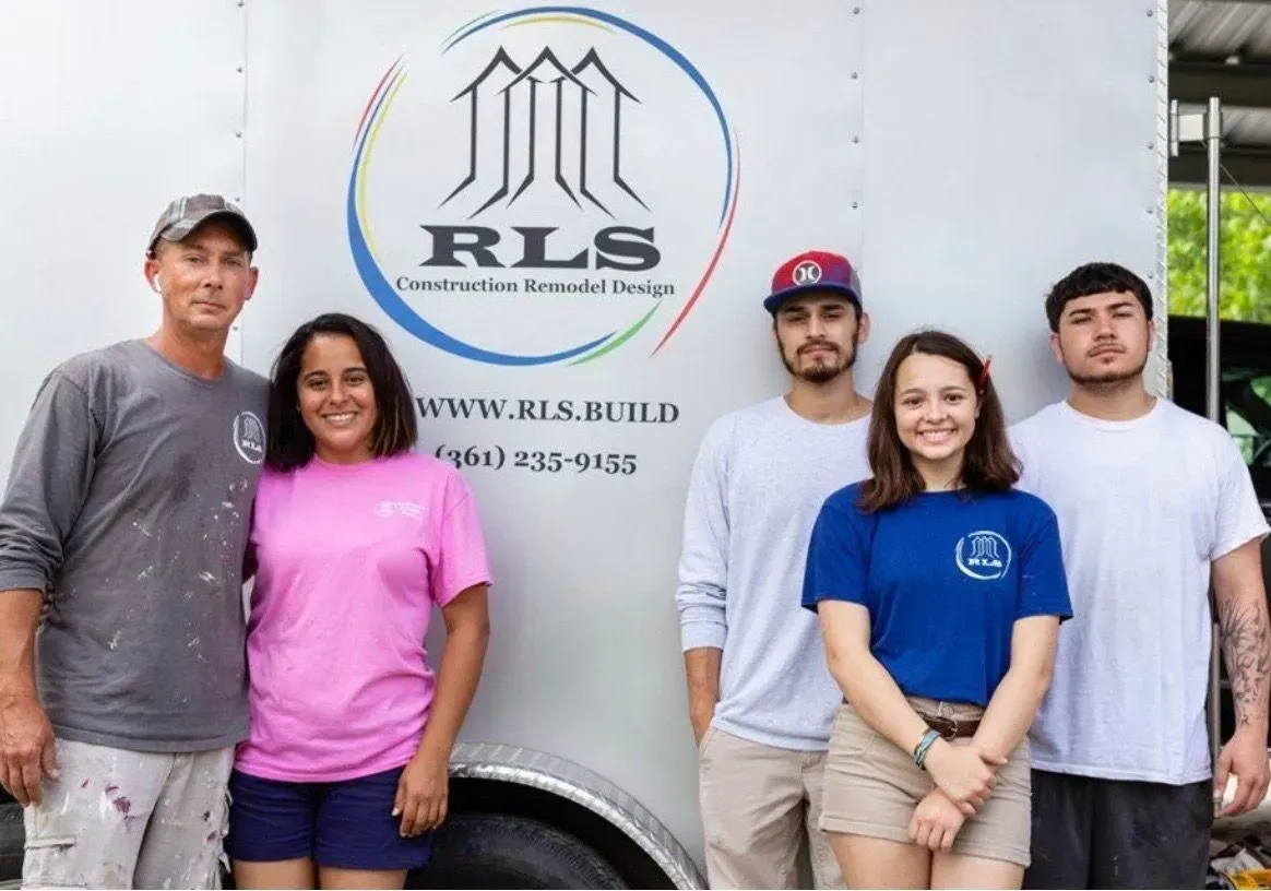 Group of 5 people standing in front of a truck with a company logo, smiling.