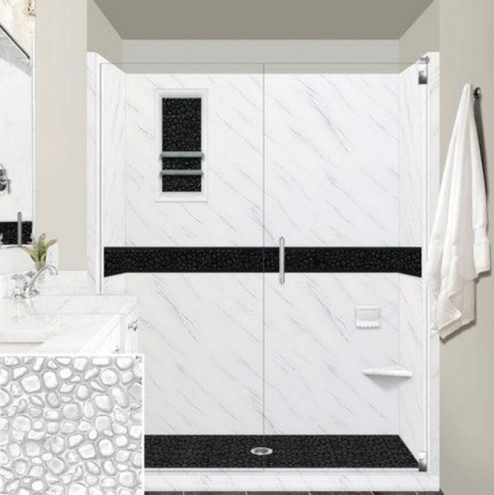 White marbled shower with black accents, glass doors, and a small pebble detail inset.
