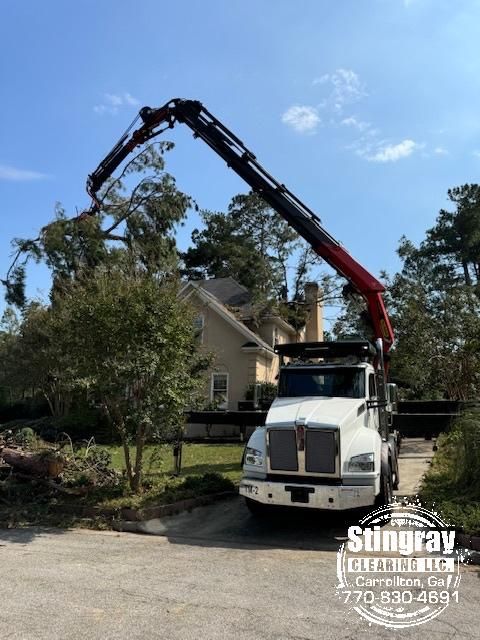 A truck with a crane attached to it is parked in front of a house.