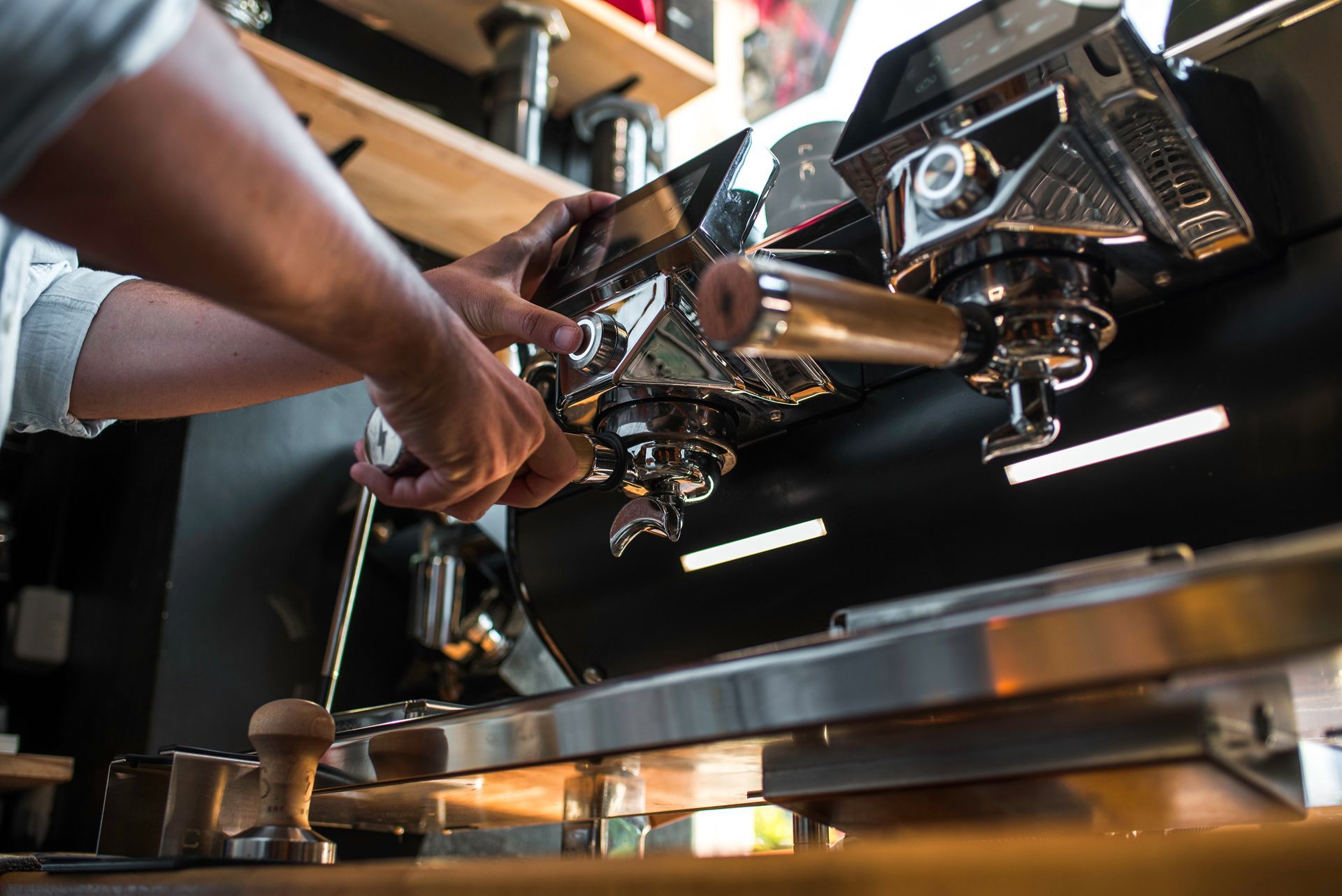 A man is working on a coffee machine in a restaurant.