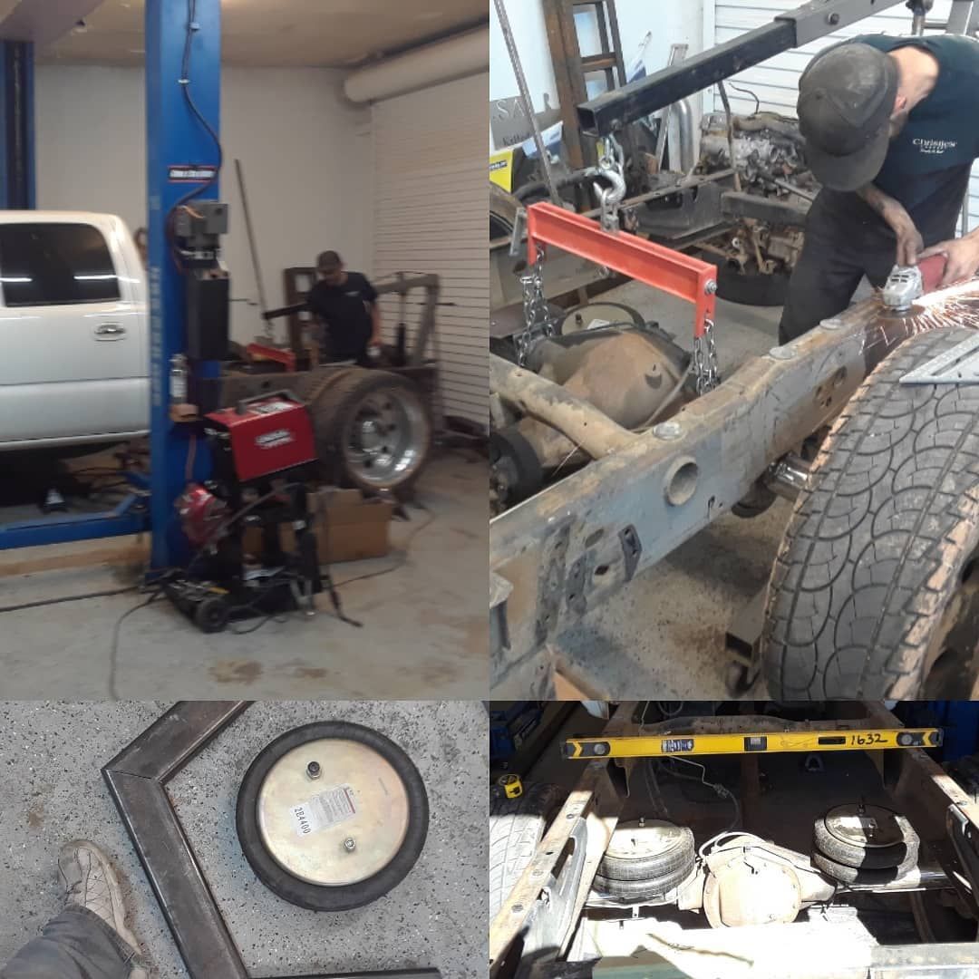 A mechanic works on a vehicle in a garage. Tools and parts are visible. The work includes welding and chassis modification.