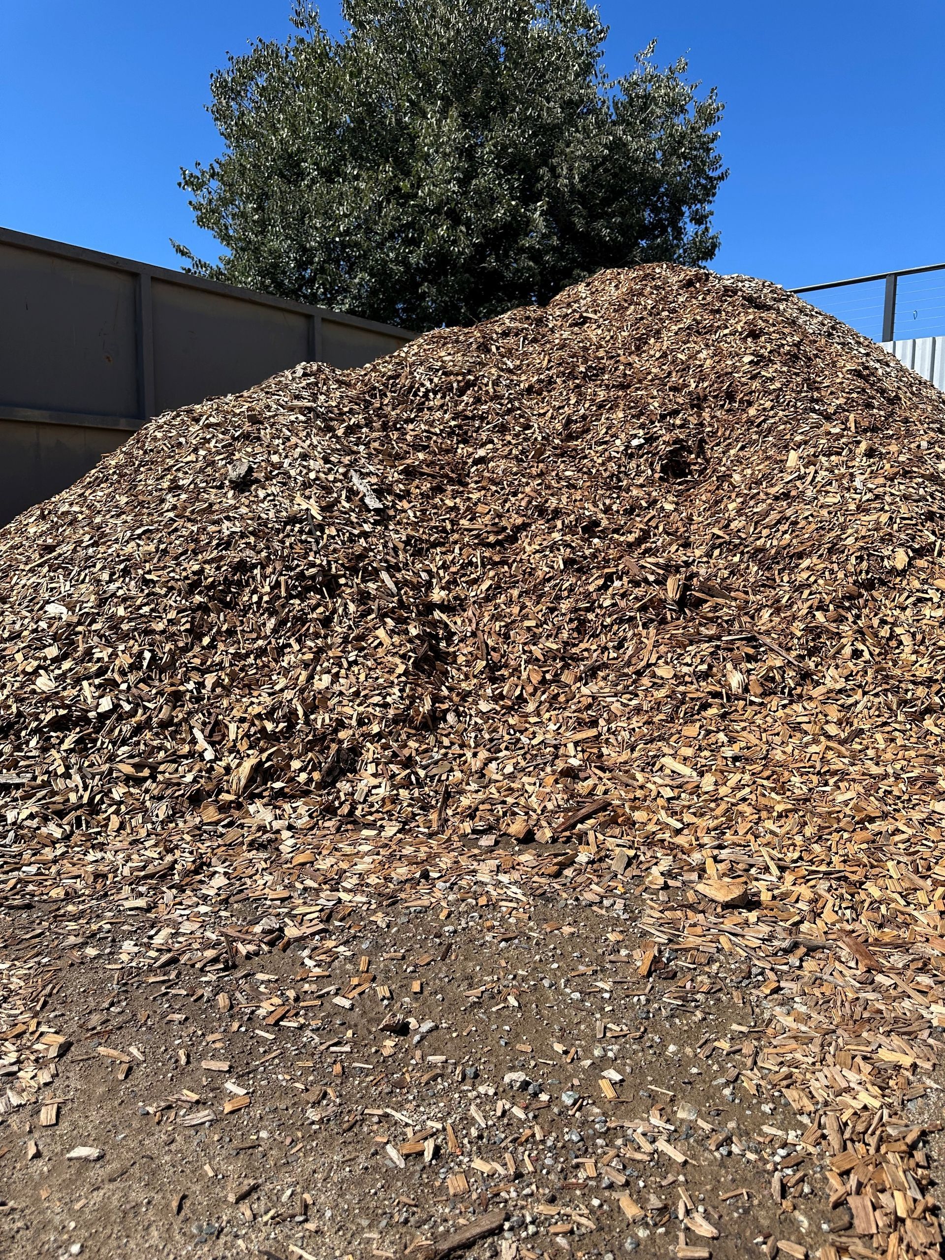 A Large Pile of Wood Chips is Sitting on Top of a Dirt Field — Dampier Street Landscape Supplies in Taminda, NSW