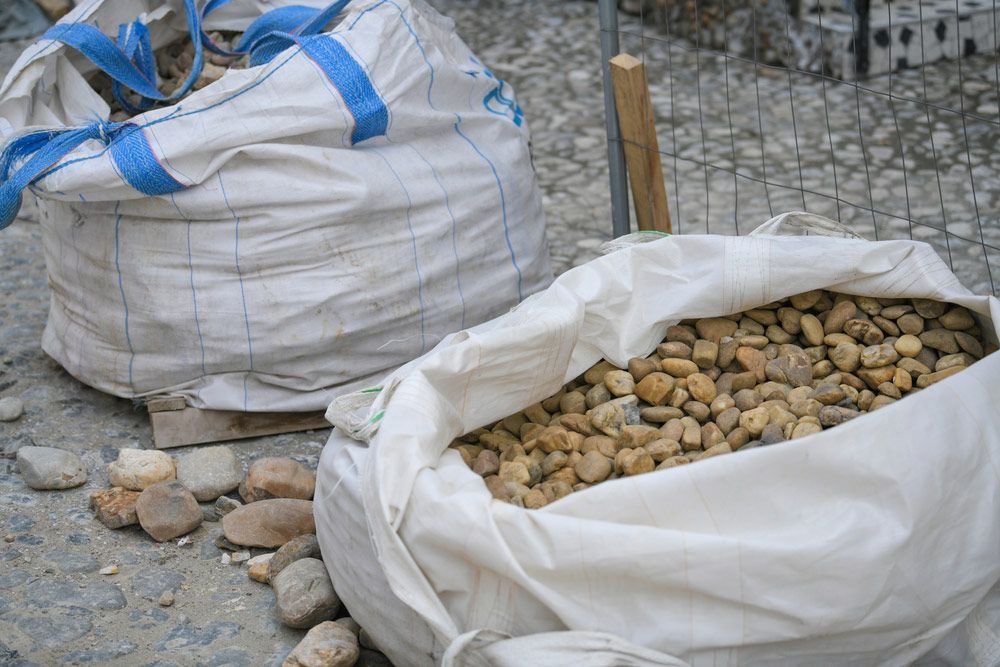 Two Bags of Rocks Are Sitting on the Ground Next to Each Other — Dampier Street Landscape Supplies in Taminda, NSW