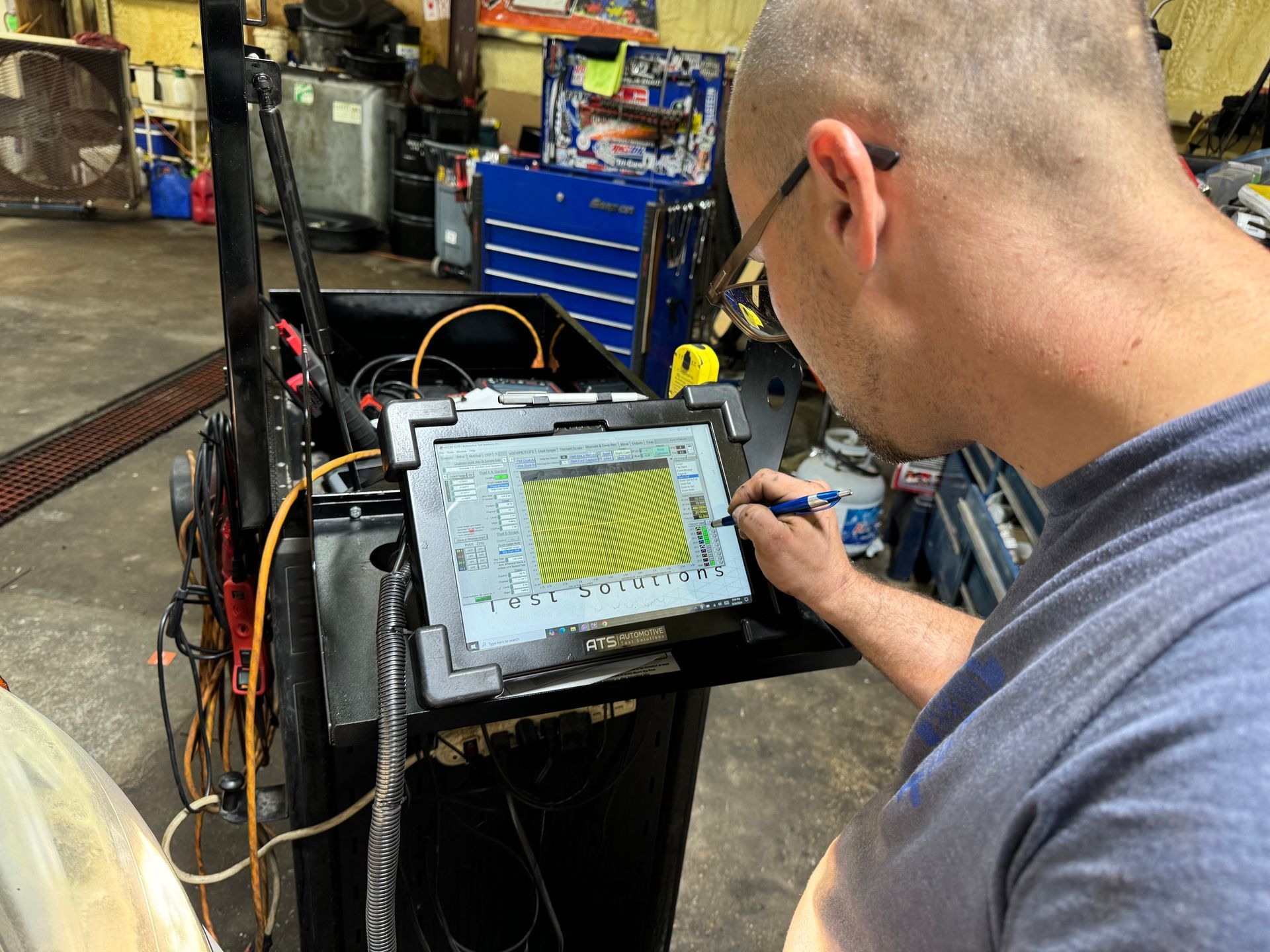 Mechanic using a diagnostic tablet in a garage. Examining data with a stylus. | Sonny's Auto Repair