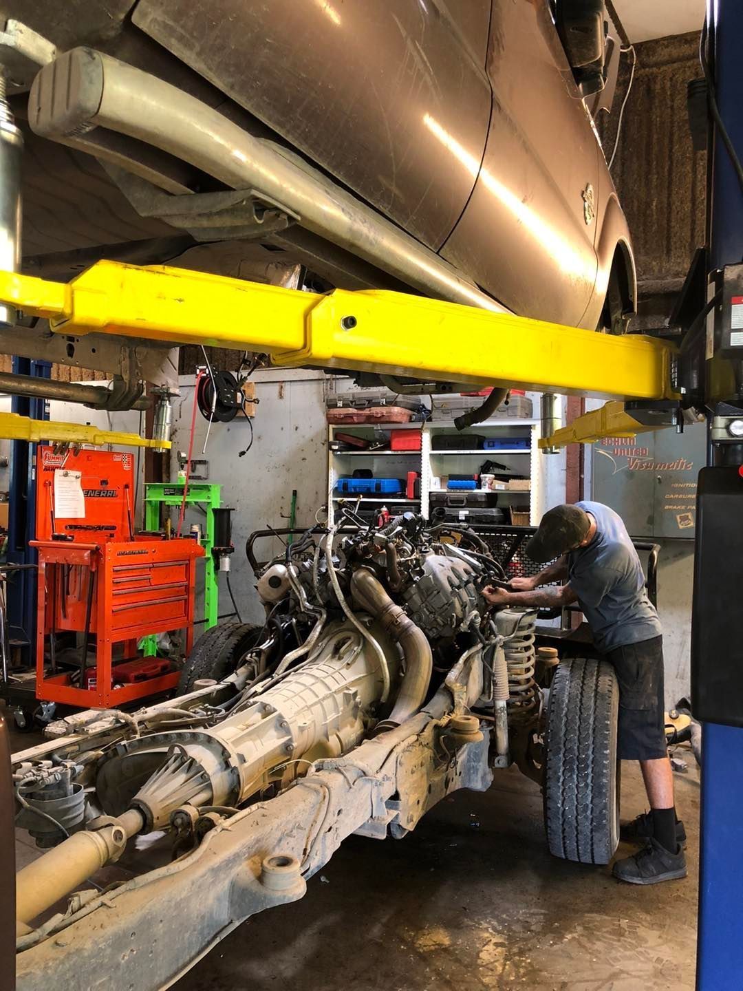 Mechanic working on vehicle chassis under a lift in a garage | Sonny's Auto Repair
