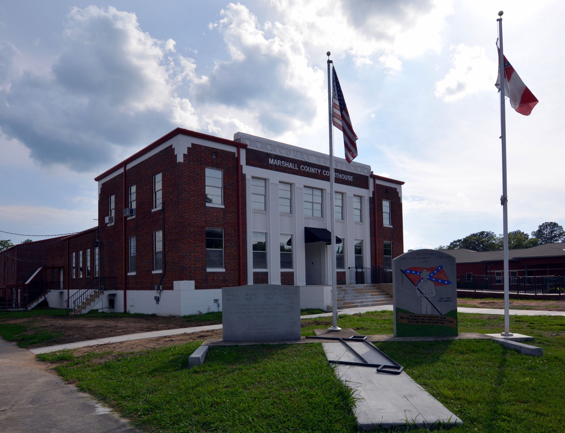 A brick building with two flags in front of it