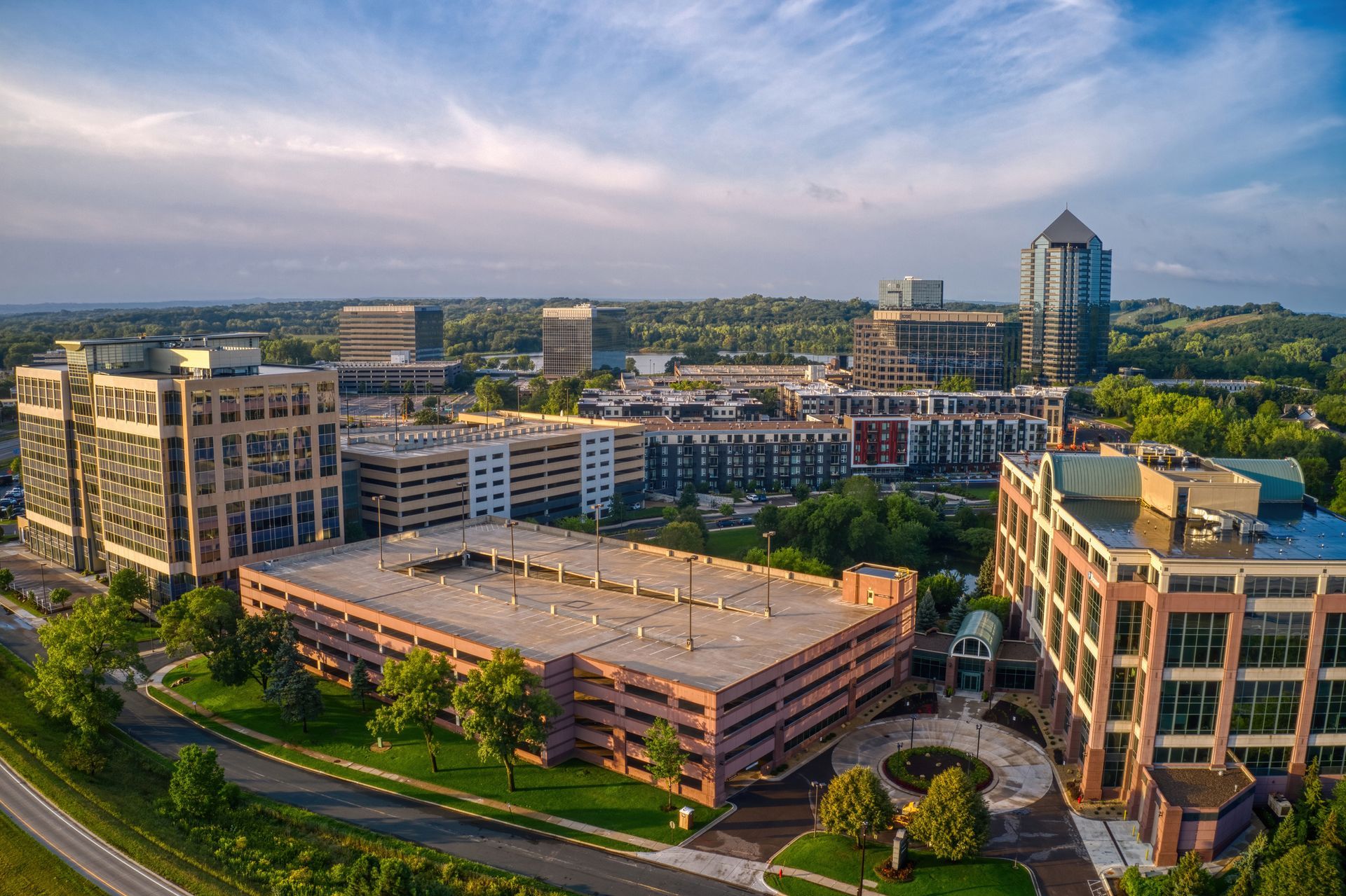 An aerial view of a city with lots of buildings and a parking garage.
