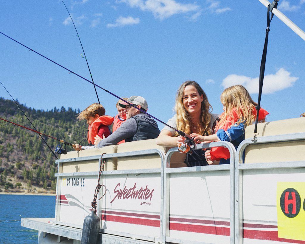 Family fishing on red and white pontoon boat