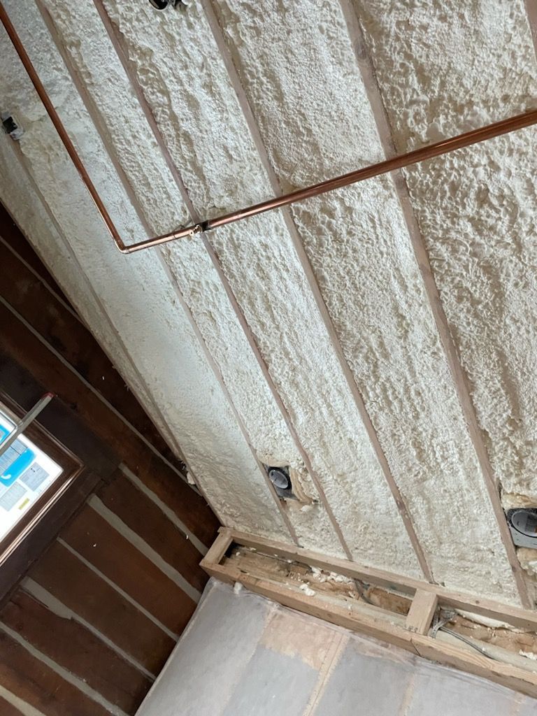 A room with a ceiling covered in foam and pipes.