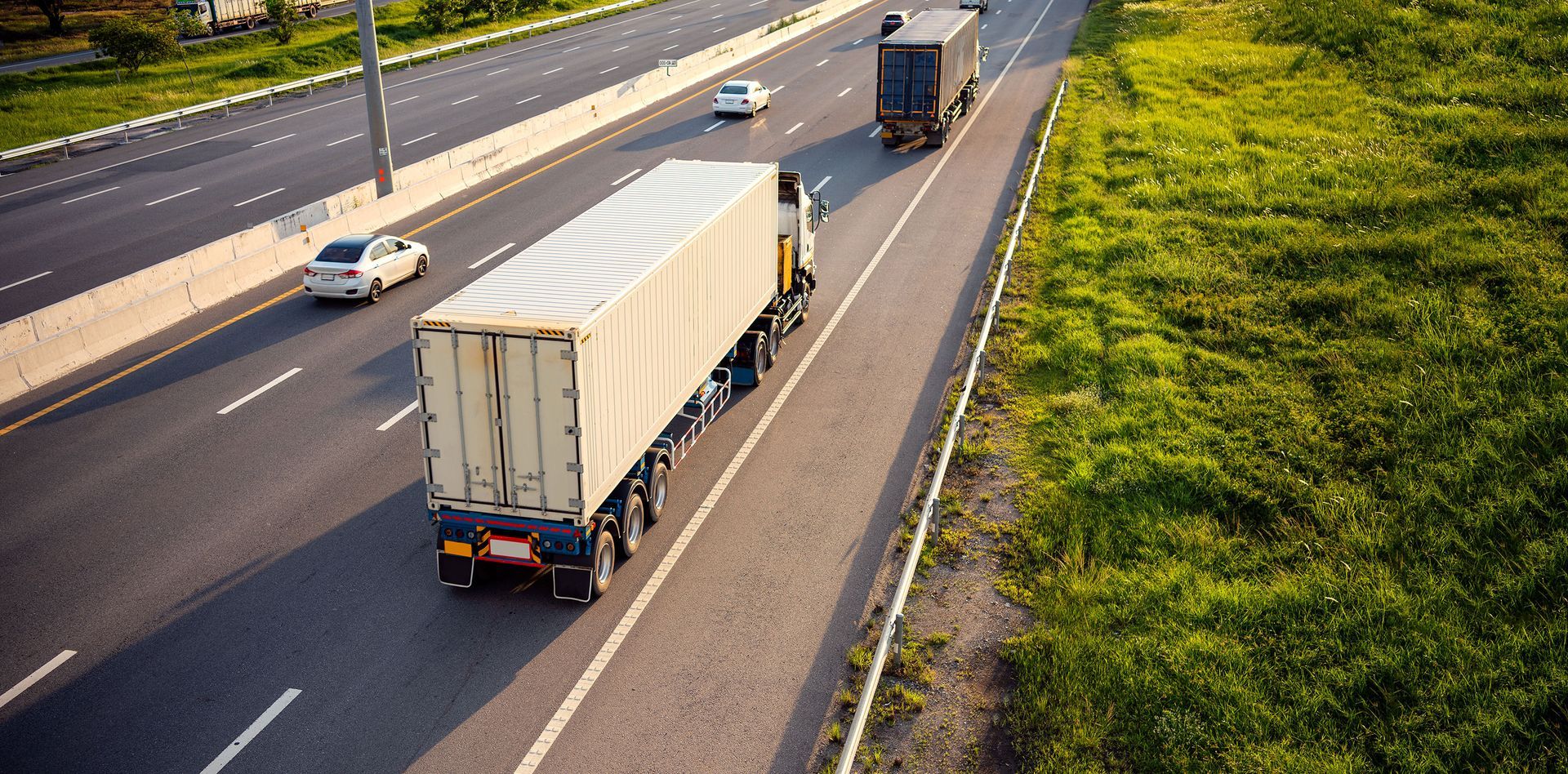 A group of semi trucks are driving down a highway.