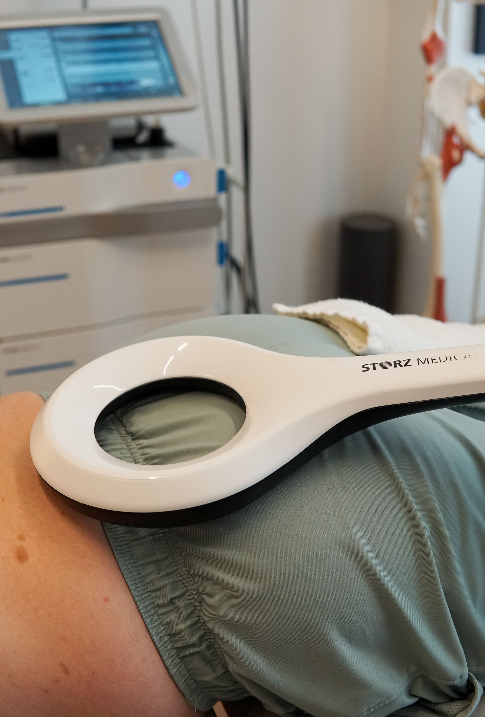 A person is laying down with a device on their stomach.
