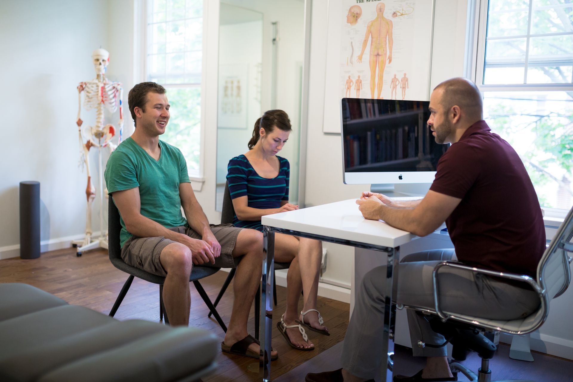 A man and a woman are sitting at a table talking to a doctor.