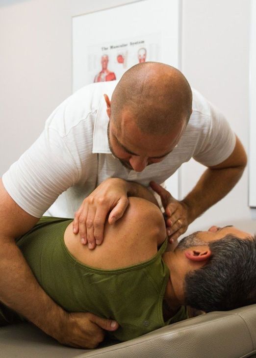 A man is giving a man a massage on a table.