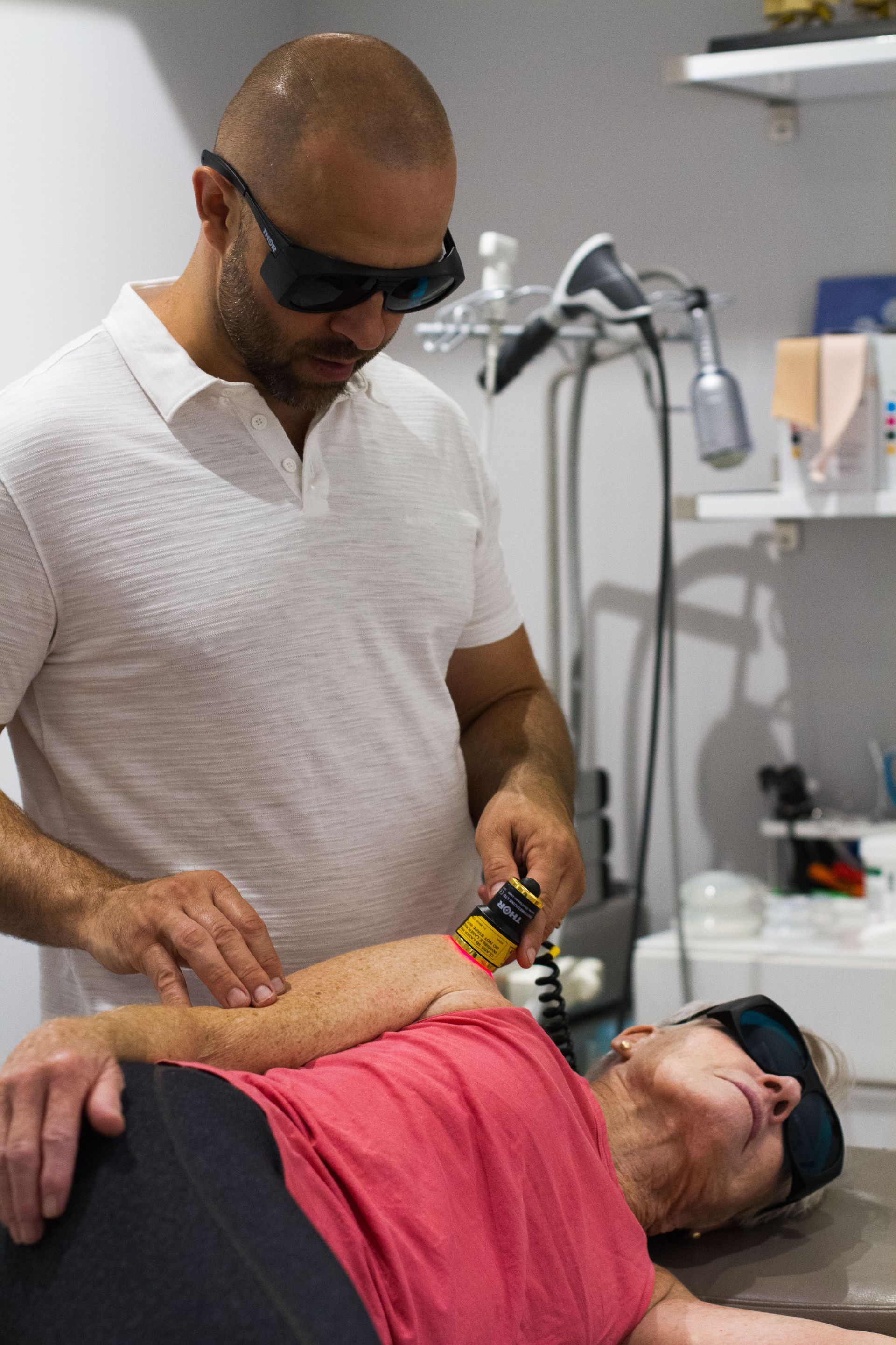 A person is getting a red light treatment on their elbow