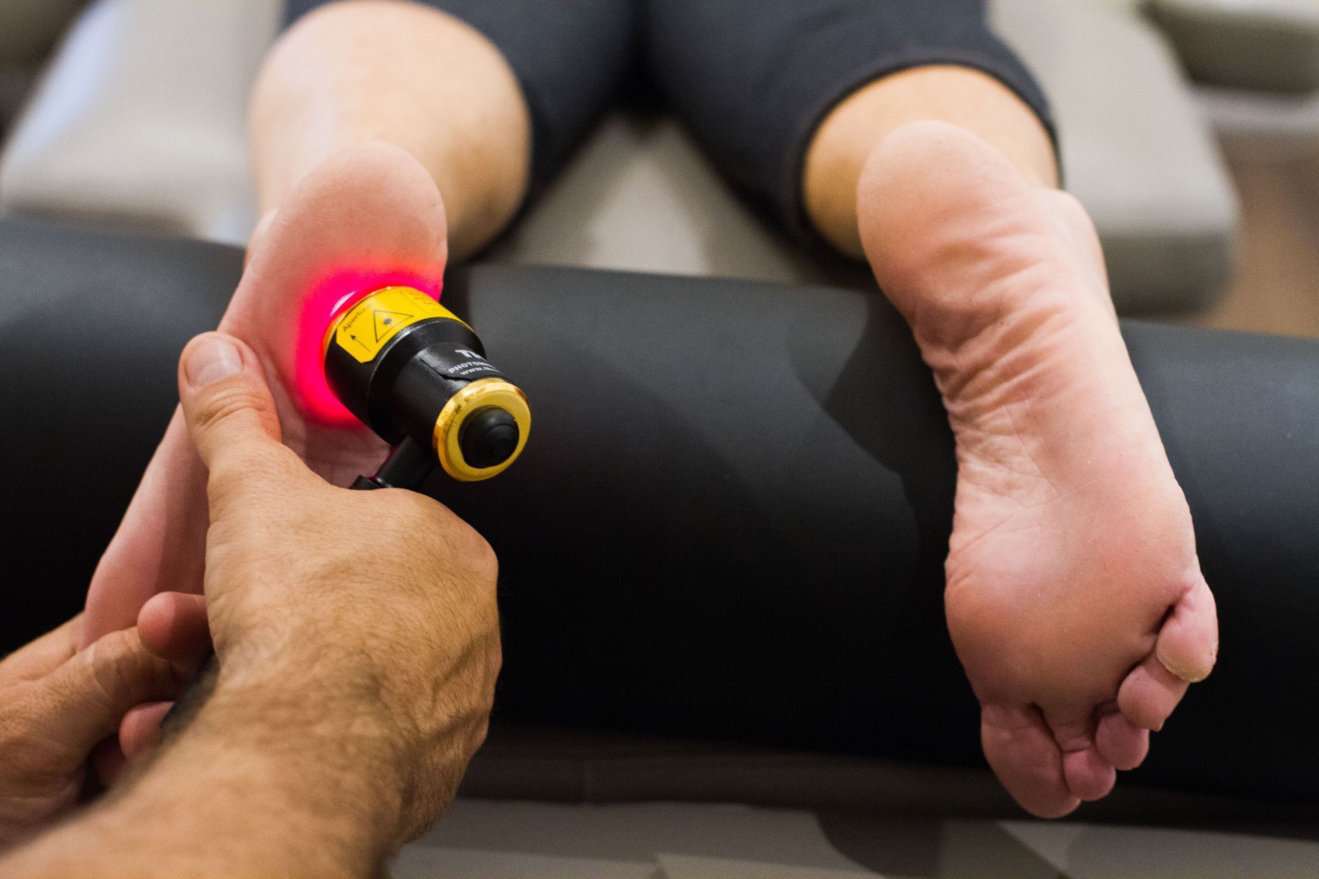 A woman is getting a laser treatment on her foot.