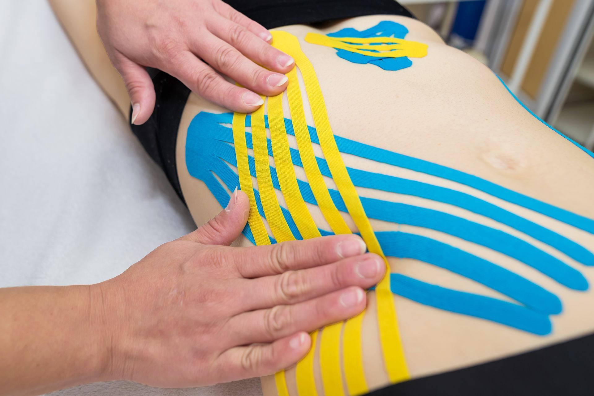 A person is getting a massage with kinesio tape on their back.