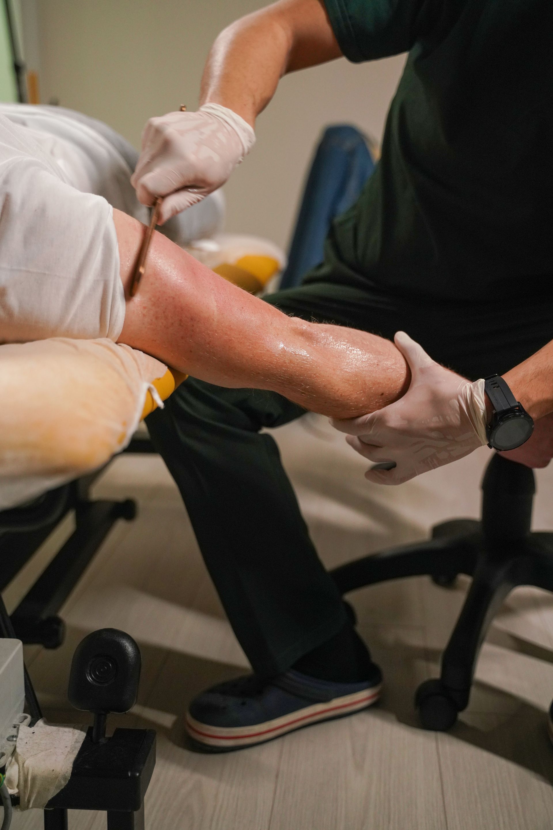 A doctor is giving a patient an injection in their leg.