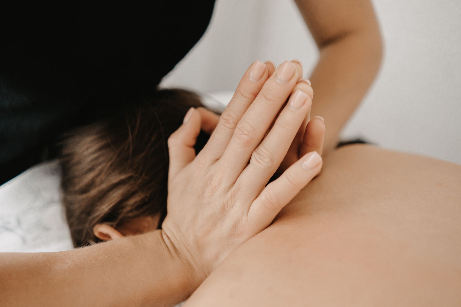 A woman is getting a massage with her hands on her back.