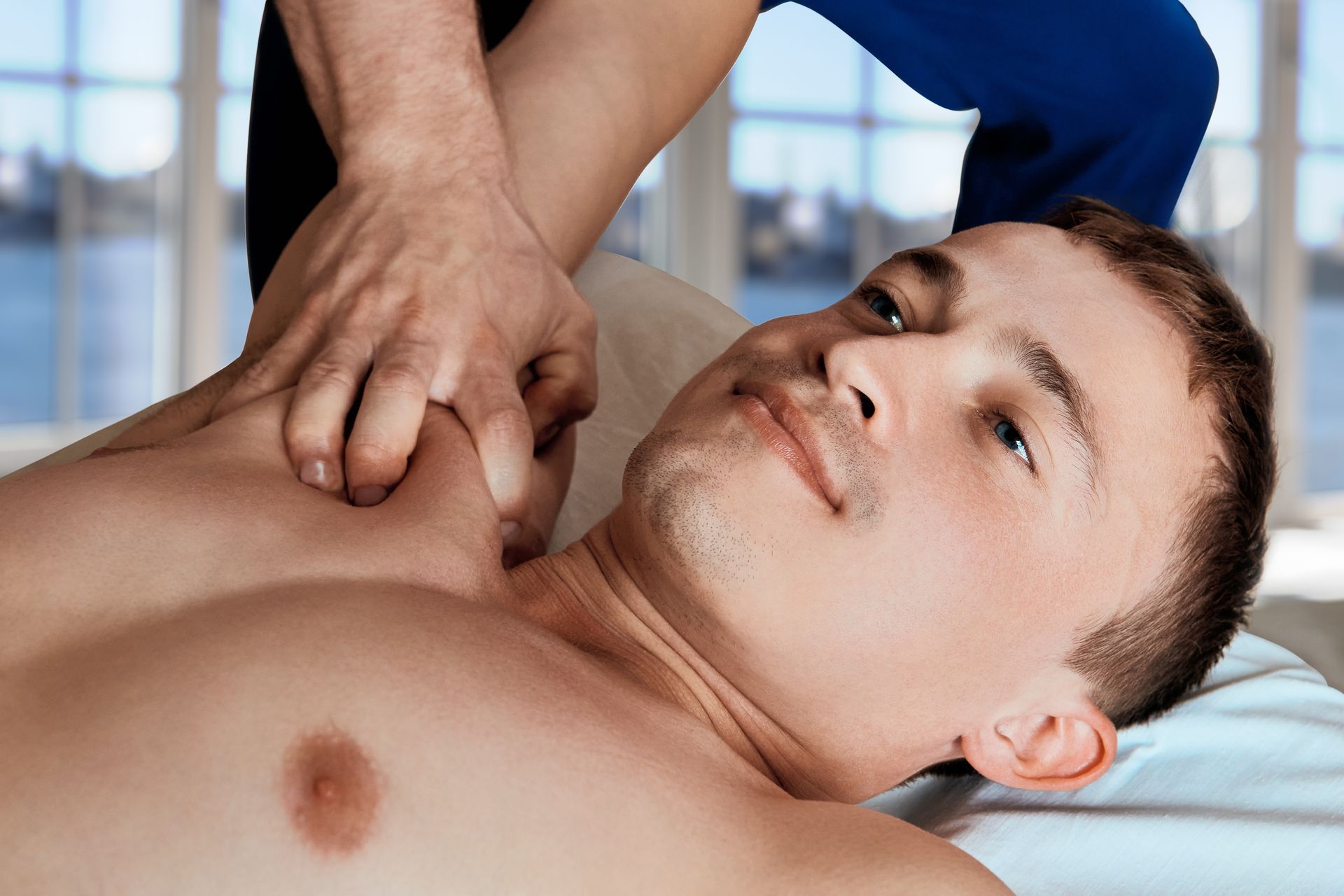 A woman is giving a man a massage on a table.