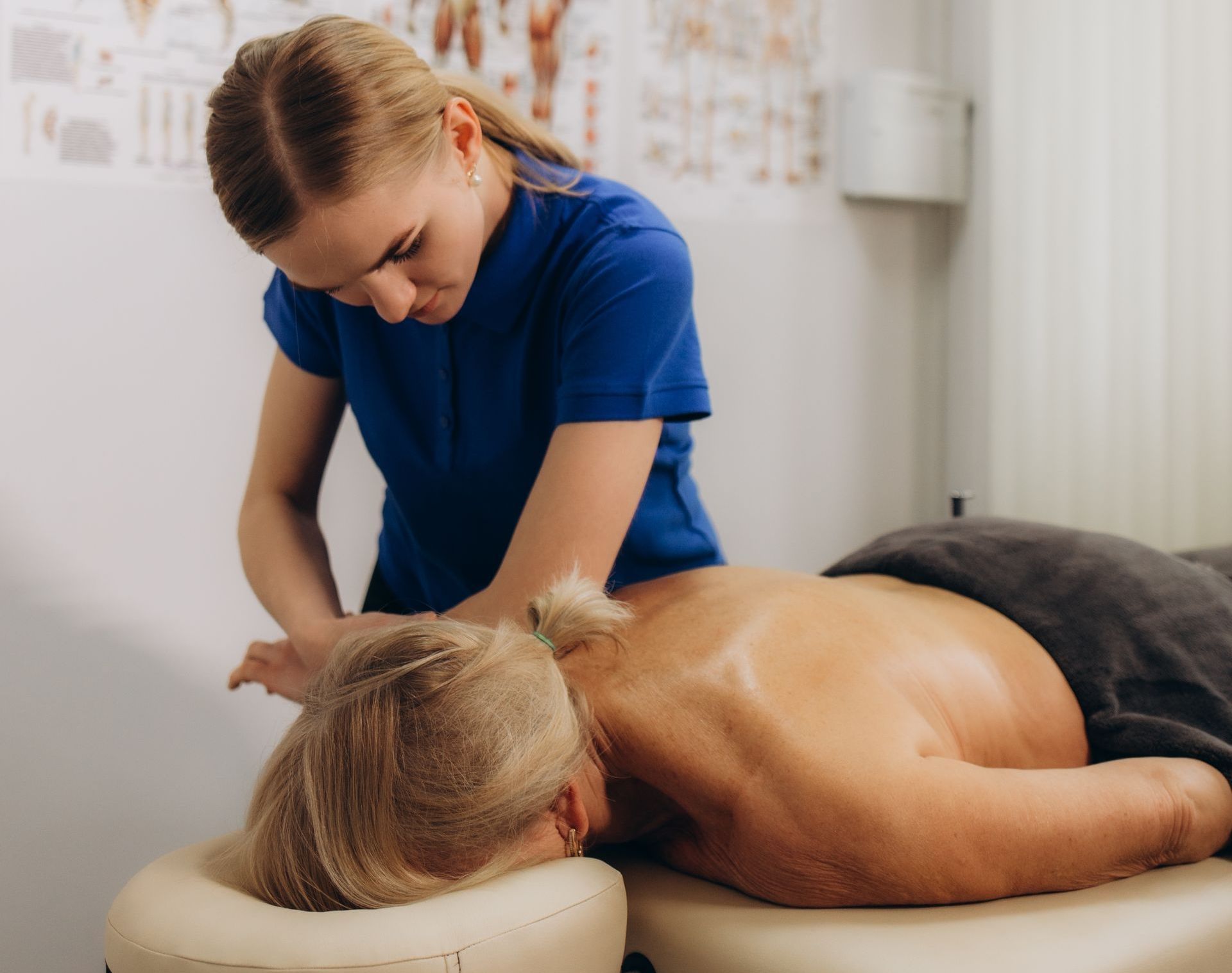 A woman is giving a man a massage on a table.