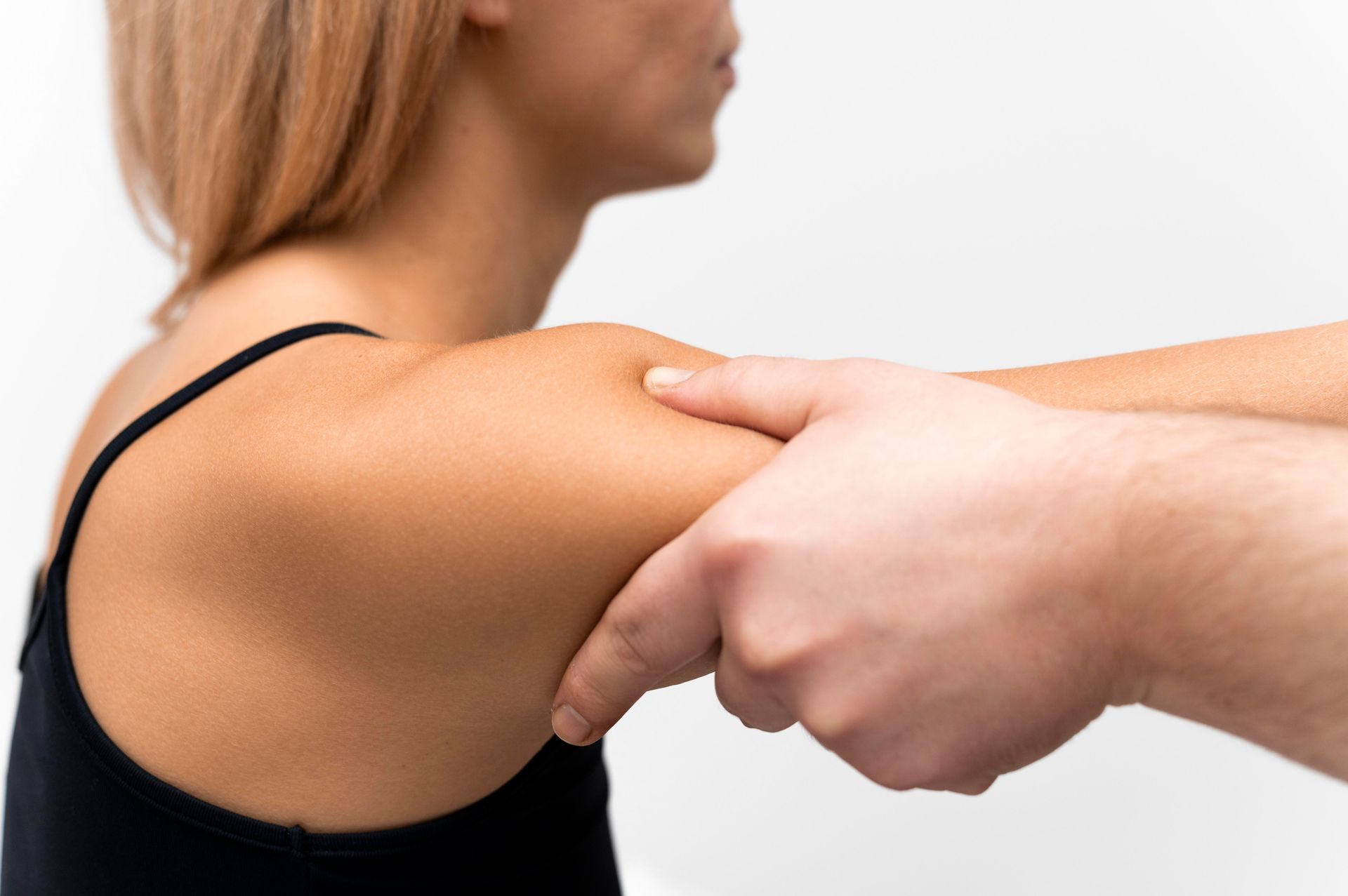 A man is giving a woman a massage on her shoulder.