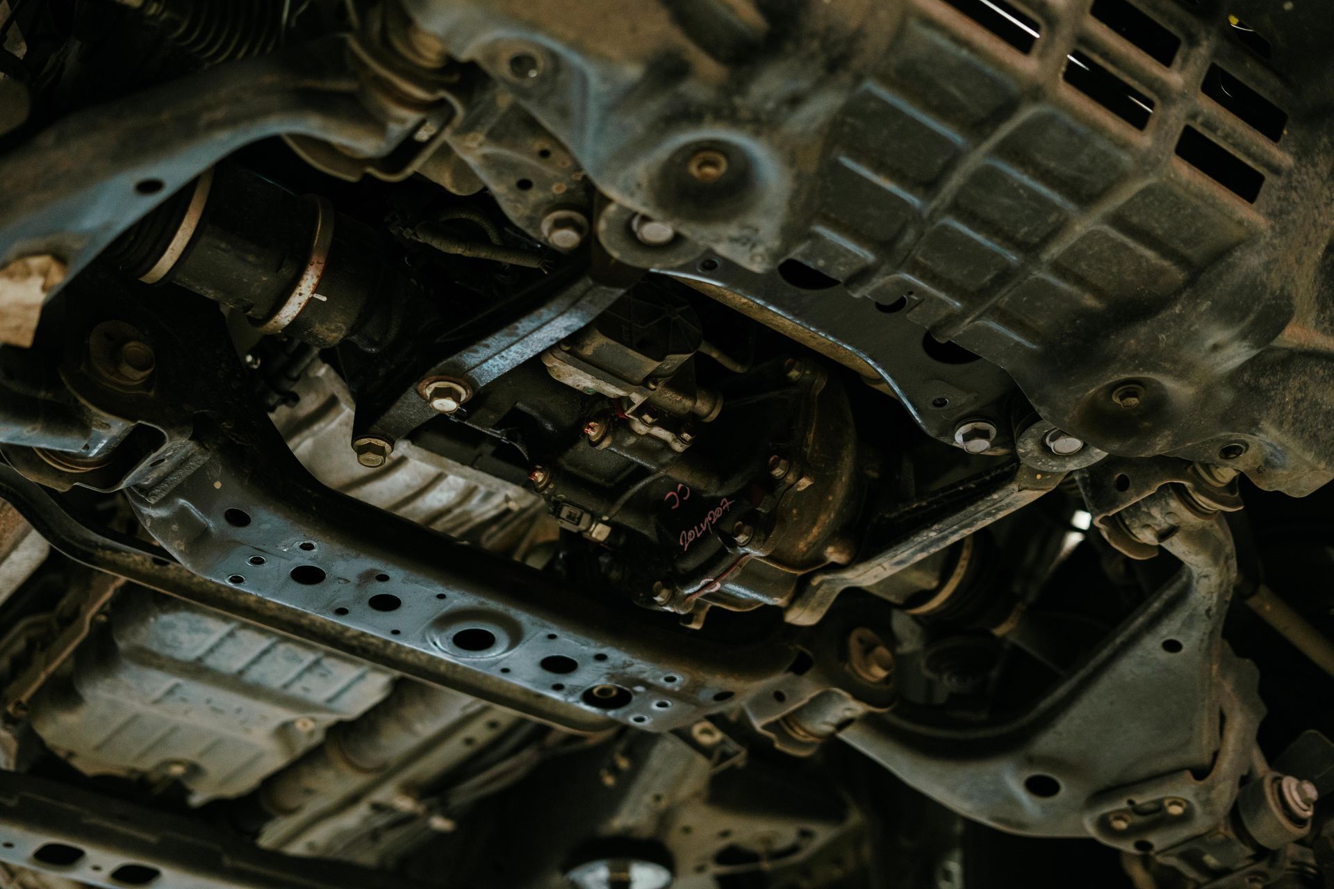 Underside view of a vehicle's drivetrain, showing axles, suspension, and undercarriage components, viewed from below. β 100% Automotive In South Nowra, NSW