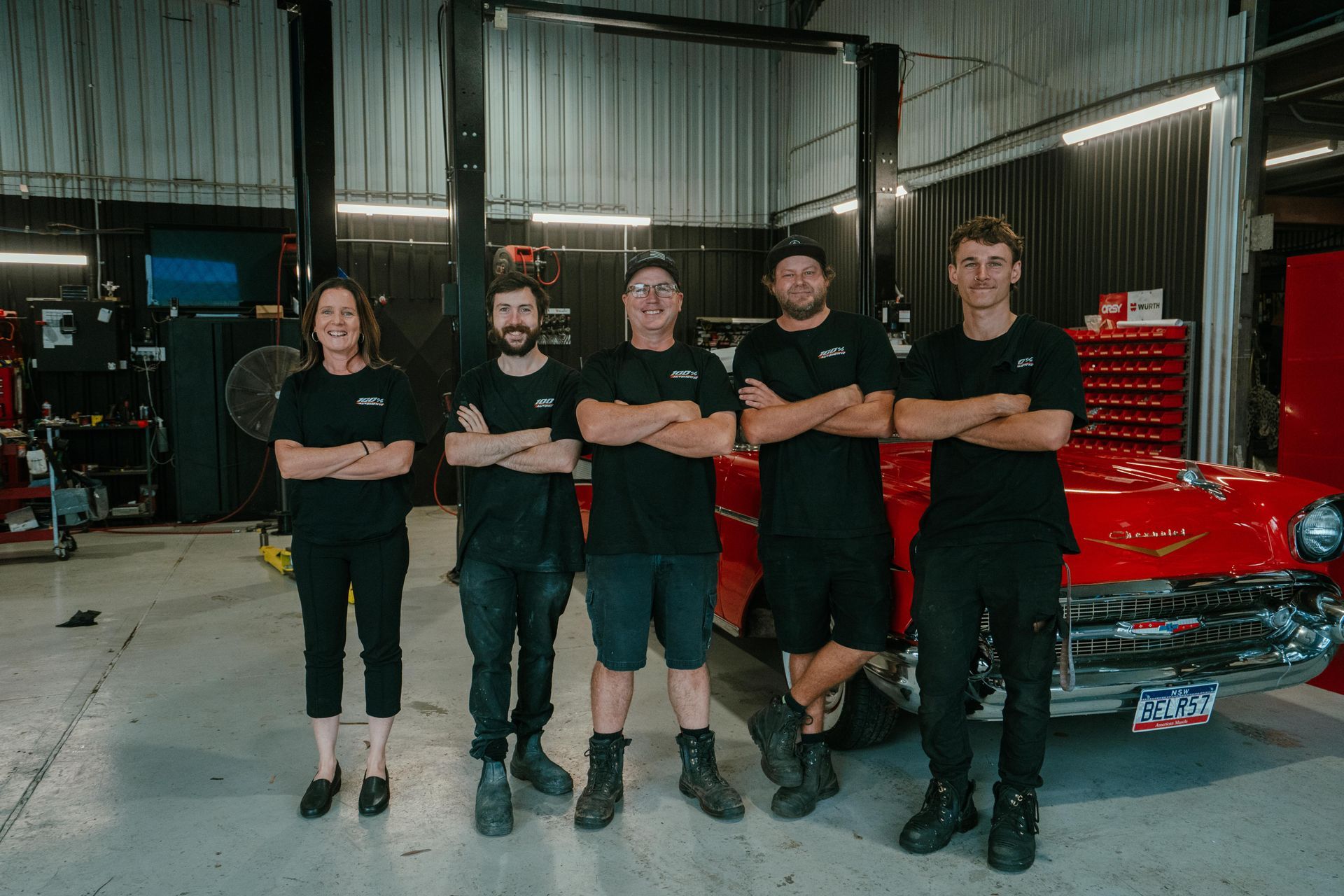 A Man Is Working On A Car In A Garage — 100% Automotive In South Nowra, NSW