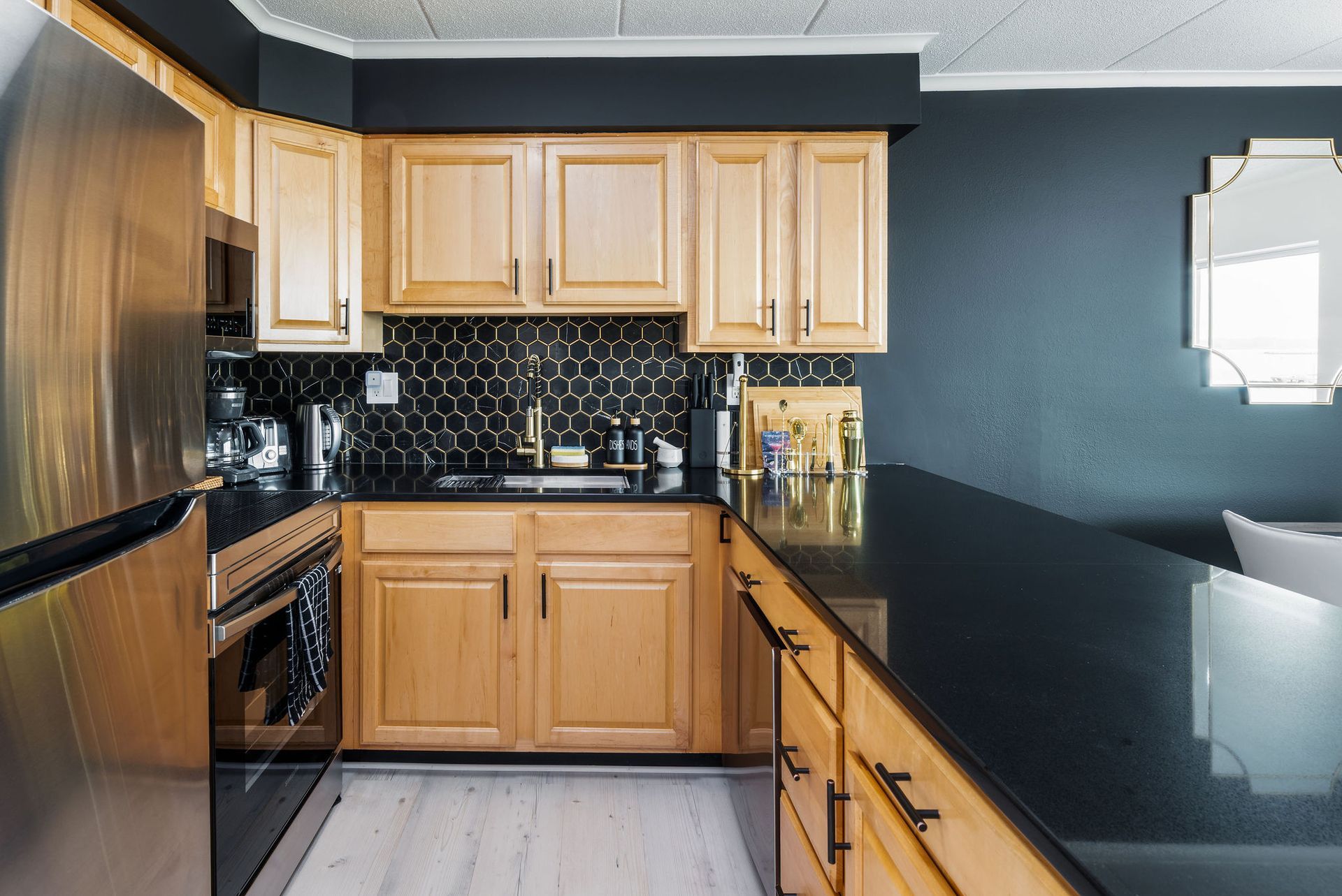 A kitchen with wooden cabinets and black counter tops