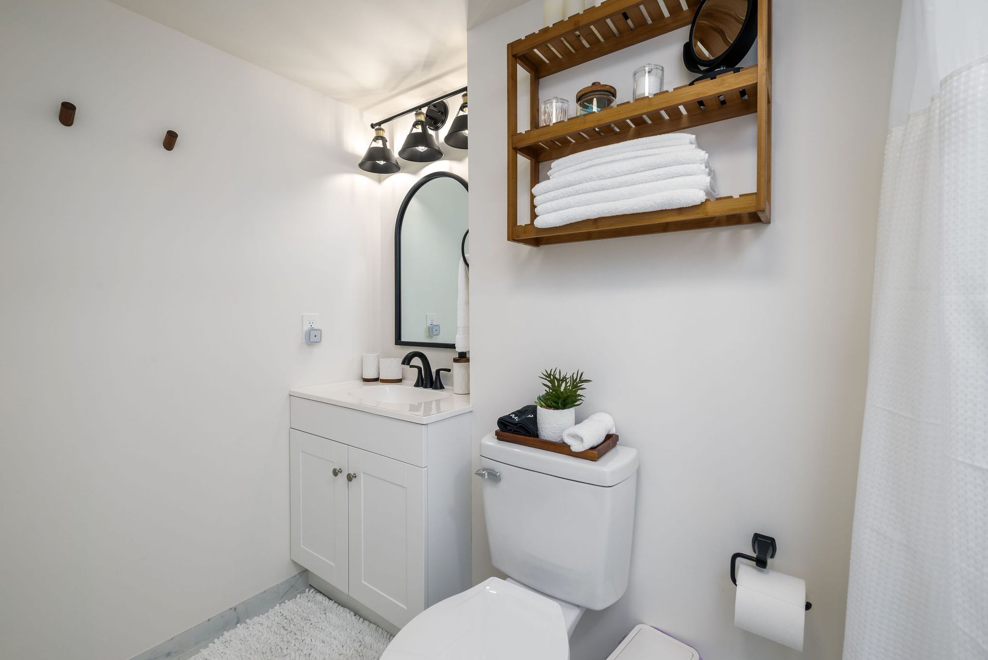 A bathroom with a toilet, sink and mirror.