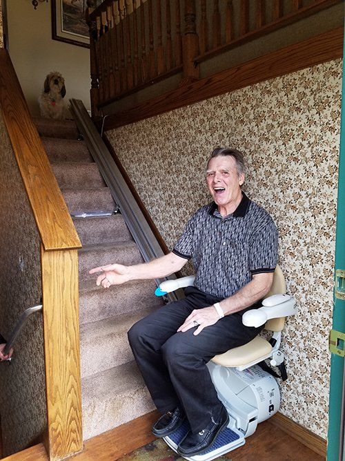 Senior Man Sitting on Stair Lift — Minneapolis, MN — Independent Living Solutions