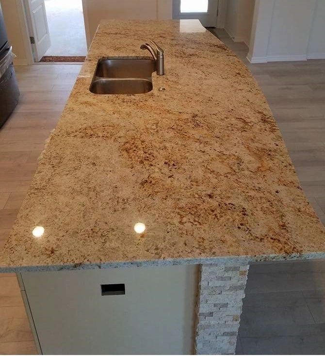 A kitchen with a granite counter top and a sink