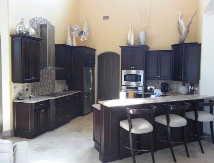 A kitchen with dark cabinets and stainless steel appliances