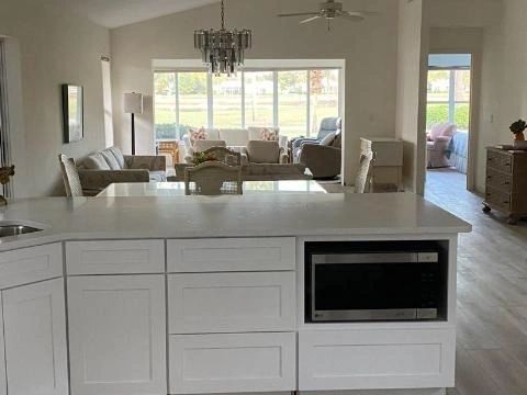 A kitchen with white cabinets and a large island in the middle of the room.